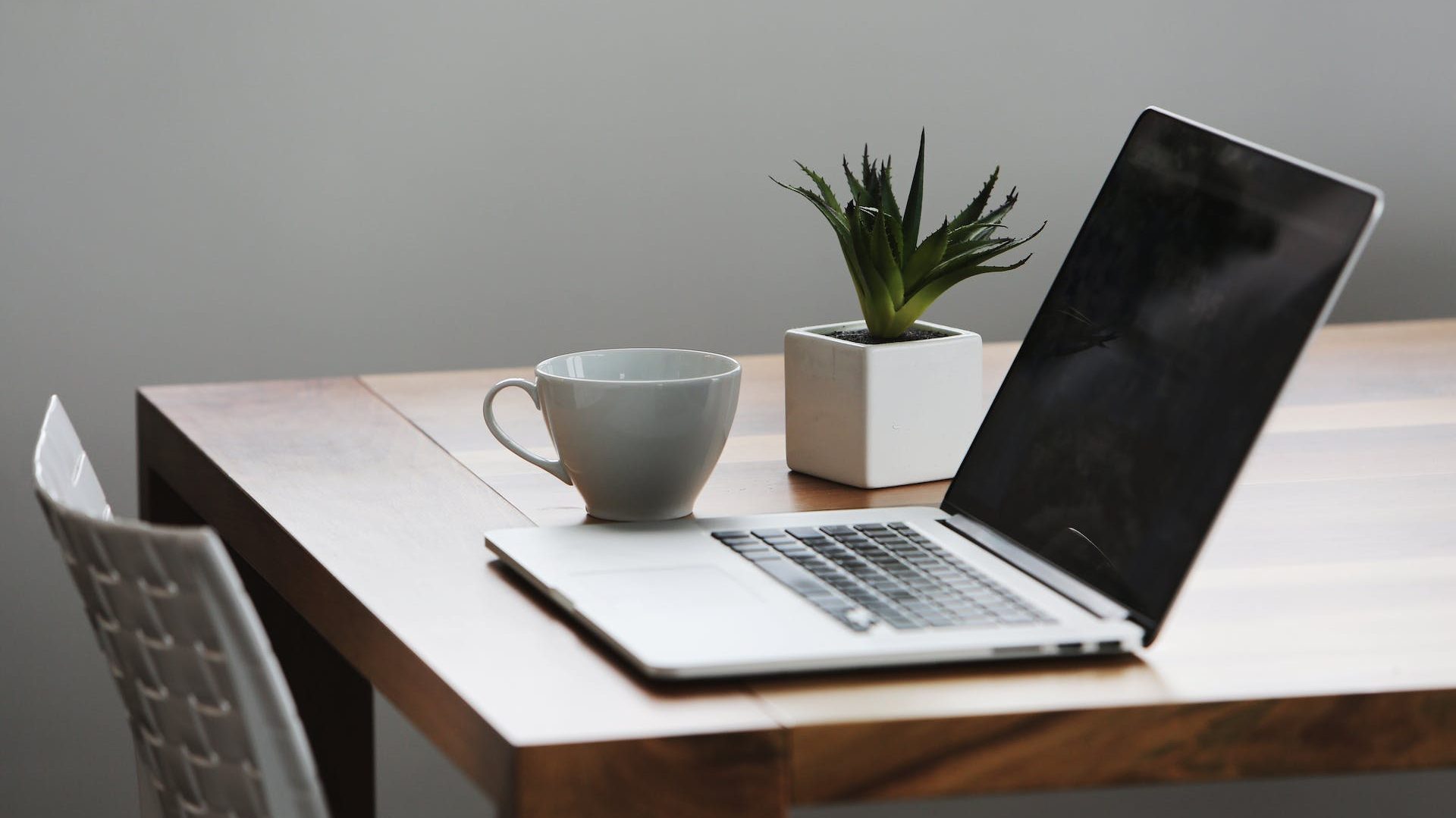 Silver Laptop Computer Next to Ceramic Cup